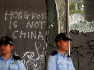 Гонконг, полиция охраняет отбитое у протестующих административное здание. Фото: https://www.novayagazeta.ru