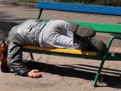 Мужчина спит на скамейке в сквере. Фото: Василий Шапошников / Коммерсант