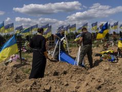 Гробовщики спускают гроб с 32-летним украинским военнослужащим Александром Матюхиным в Харькове, 23 мая 2022 г. Фото: Bernat Armangue / AP Photo